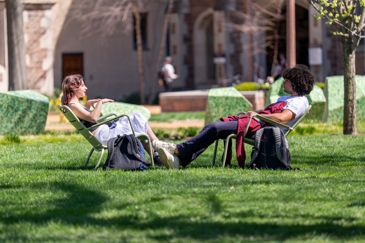 students relaxing and talking on campus